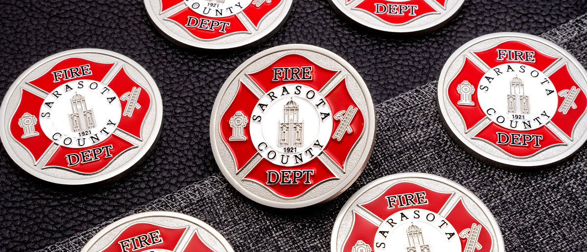 Bulk order of Sarasota County Fire Department wholesale challenge coins arranged on a black surface